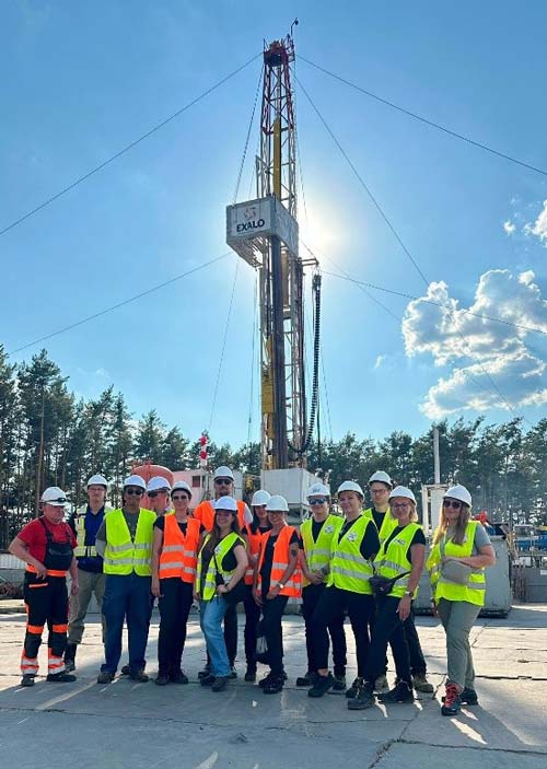 Geolodzy z PIG-PIB wraz z przedstawicielami Lumina Metals na tle masztu wiertniczego