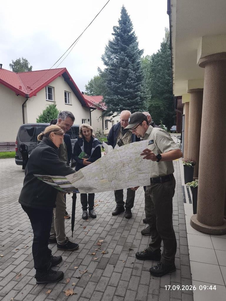 kilkoro ludzi w mieście przygląda się dużej mapie