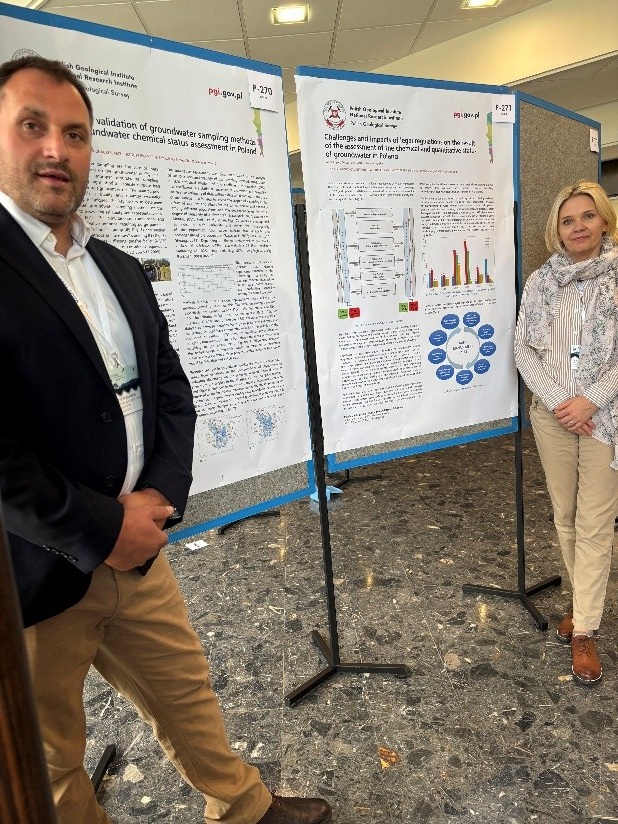 mężczyzna i kobieta pozują do zdjęcia przy posterze