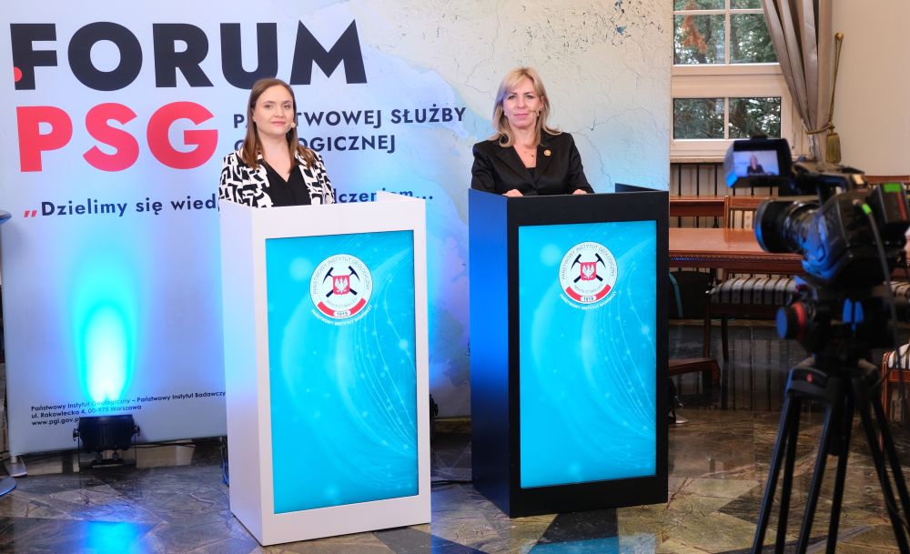 dwie kobiety stojące za mównicą w studiu nagraniowym