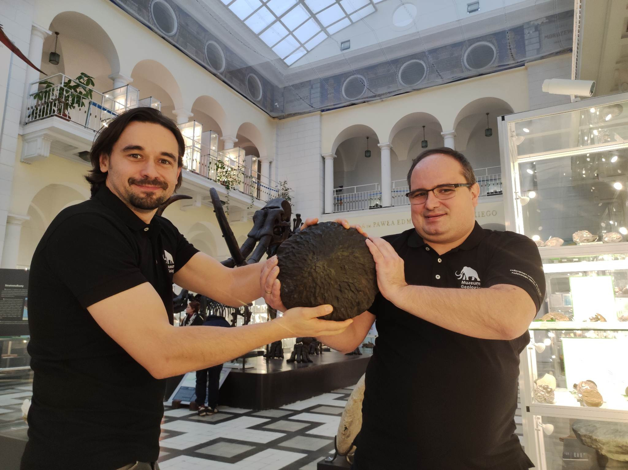 na zdjęciu prelegenci: Jan Krawczewski i Cezary Krawczyński „siłujący” się z repliką meteorytu Baszkówka