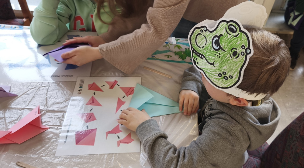 Dziecko we własnoręcznie wykonanej masce dinozaura