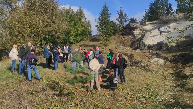 Odsłonięcie utworów miocenu w w Hucie Różanieckiej, grupa ludzi wśród skałek
